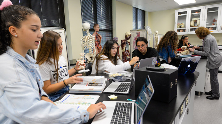 Students working on laptops in biology lab