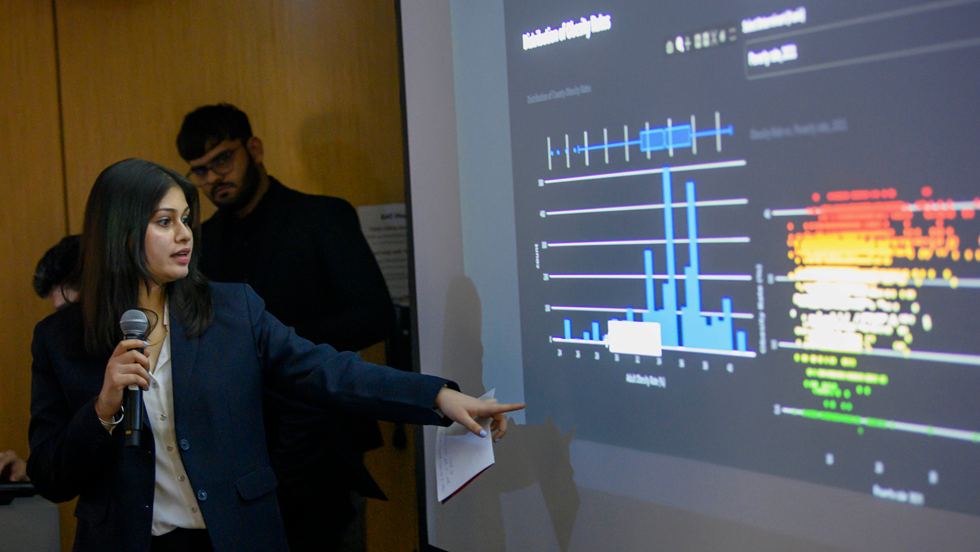 Woman pointing to data on screen while presenting