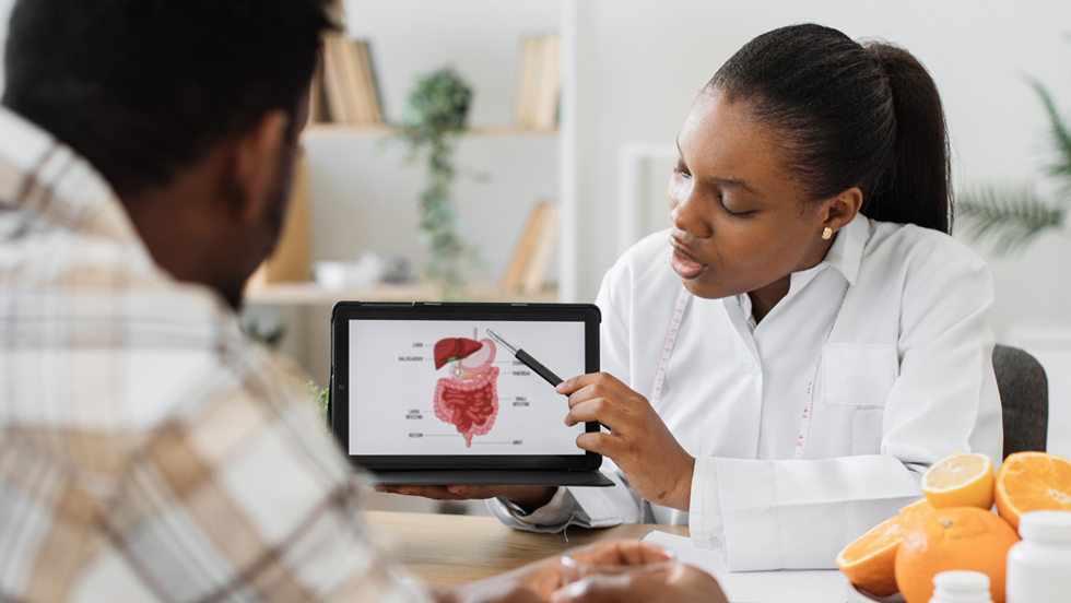 Woman showing a man a diagram of how food is processed in the body
