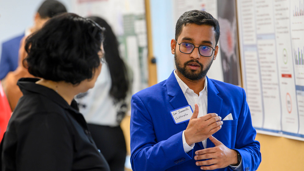 Man explaining his research project to woman