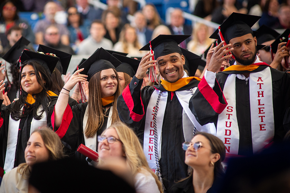 graduates turning the tassels on their caps at a commencement ceremony