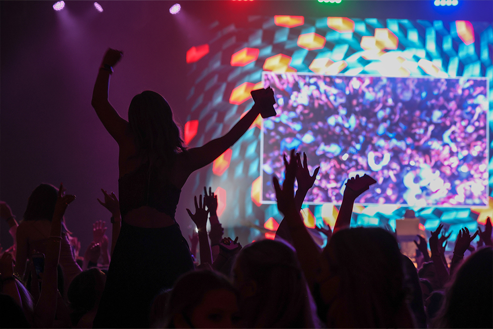 Silhouetted dancers against a colorful light display