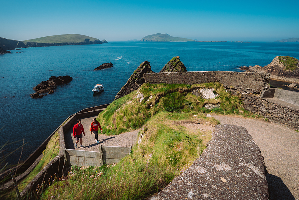two people walking along a hillside path on the Dingle Ireland coast