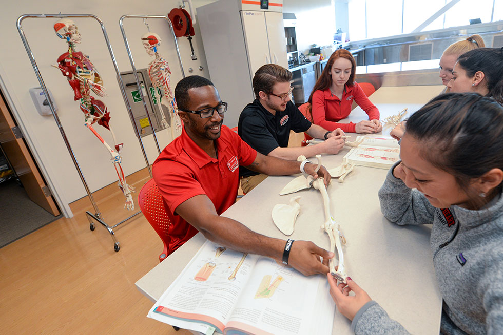 physical therapy college students looking at a skeleton