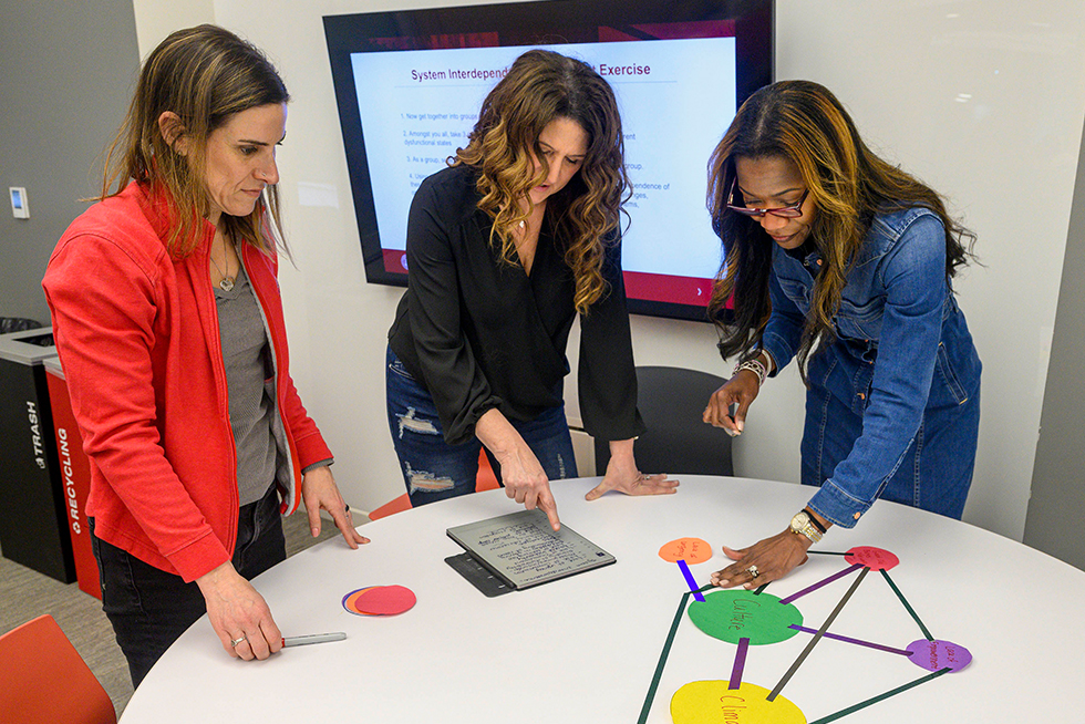 three people working together on a project in a classroom