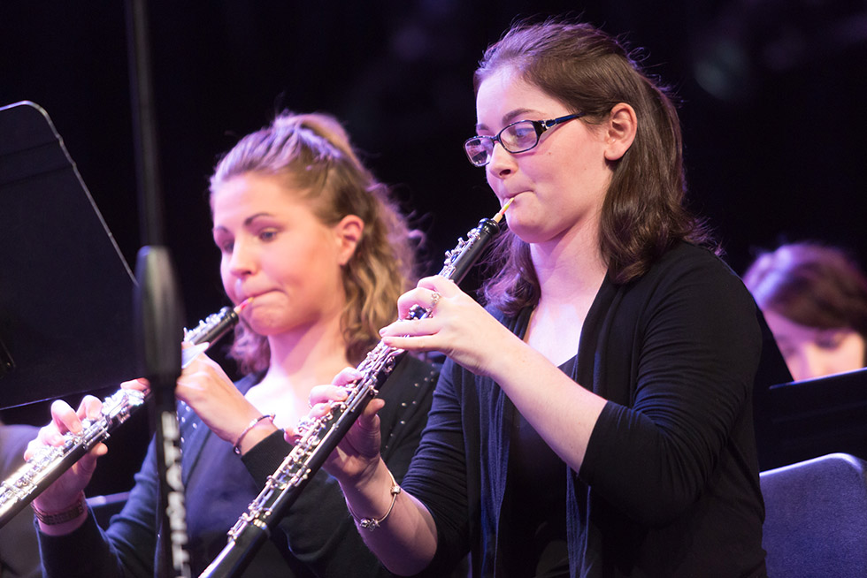 two woodwind musicians playing in a concert