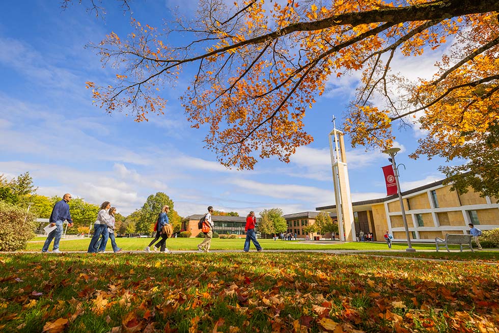people walking across a fall campus