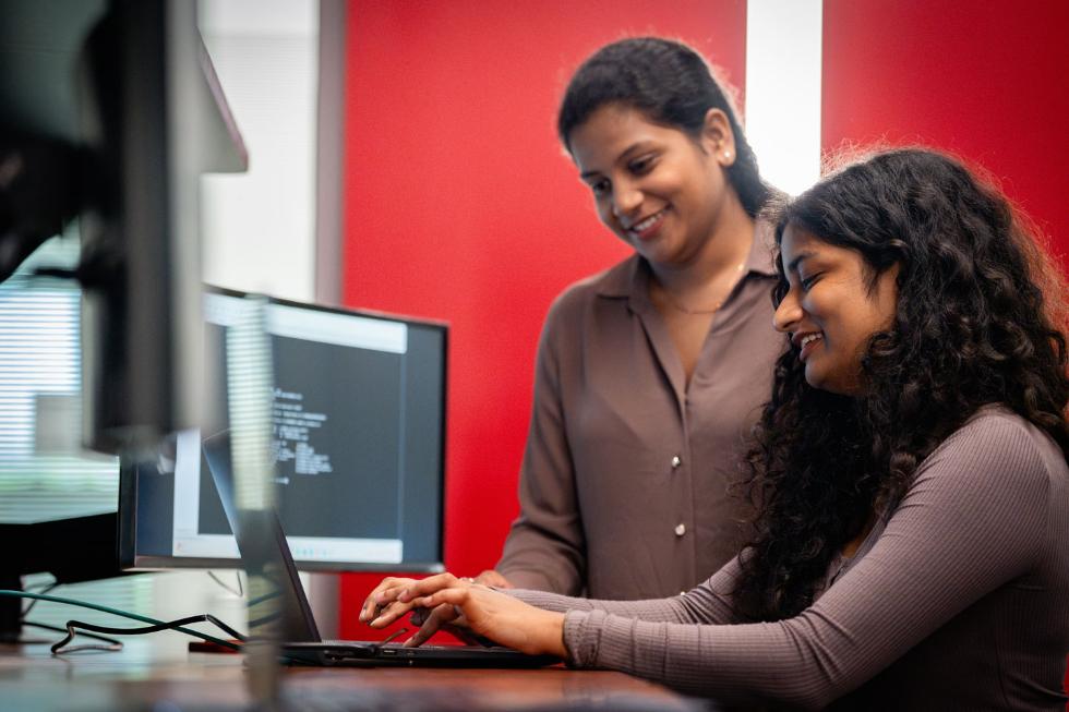 Professor helping student on computer