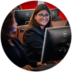Two college students looking at a computer screen in class