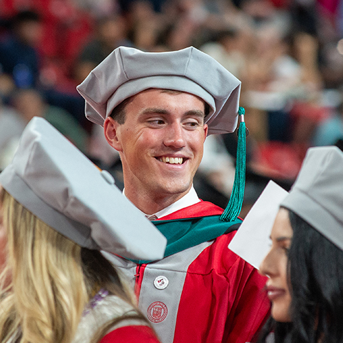 A graduate wearing a doctoral cap at a commencement ceremony