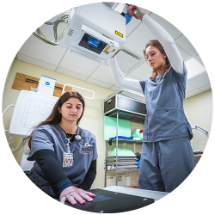 two radiography students learning to use an x-ray machine