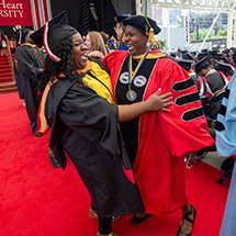 Professor hugs at student at commencement