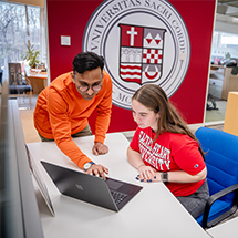 two people collaborating on a laptop