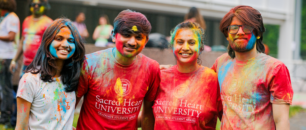 International students covered in colored powder to celebrate Holi
