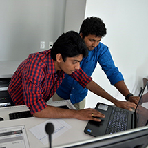 Two students working on a laptop