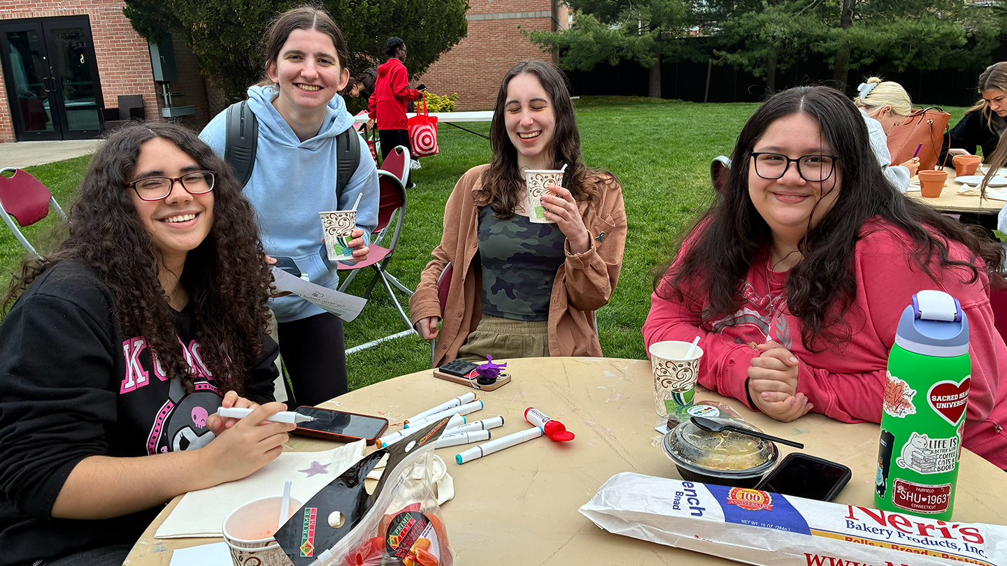 a group of friends doing a craft at a table