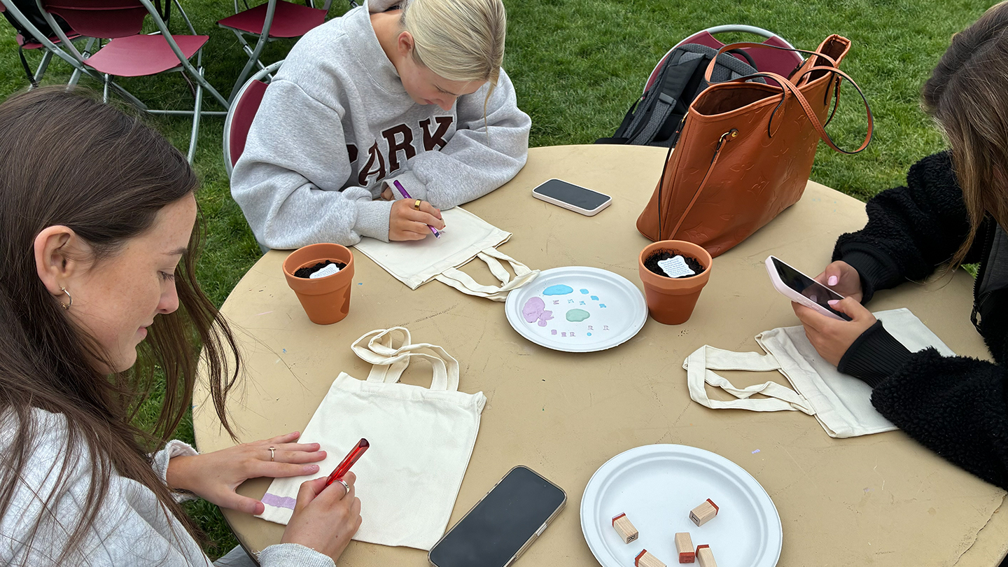two people decorating reusable canvas bags