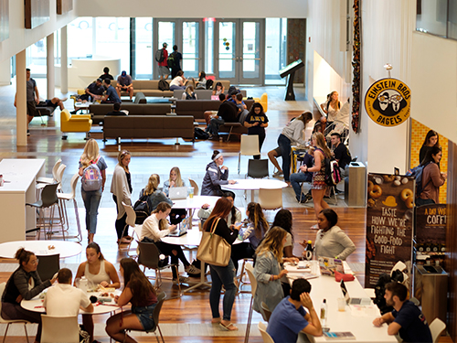 People gathered at tables in an atrium