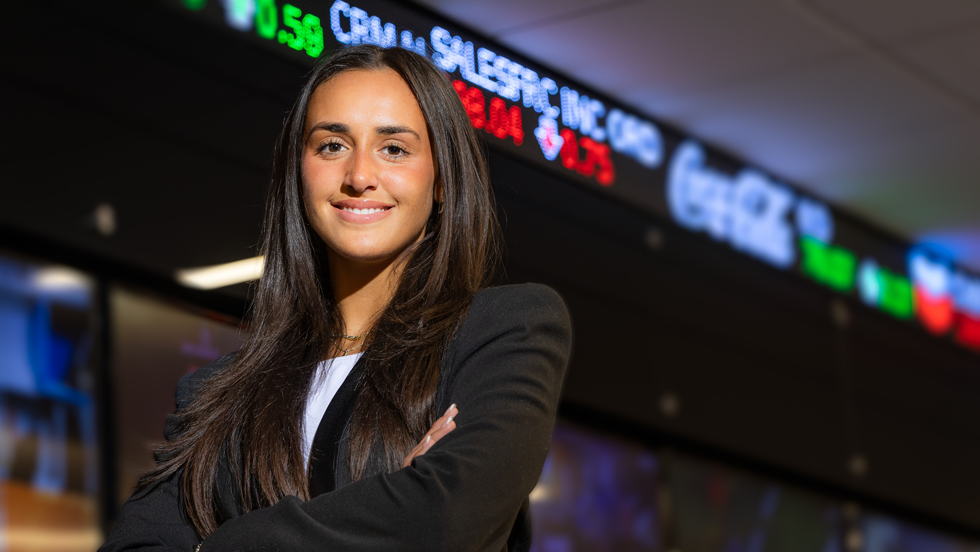 Business student standing in front of stock ticker tape