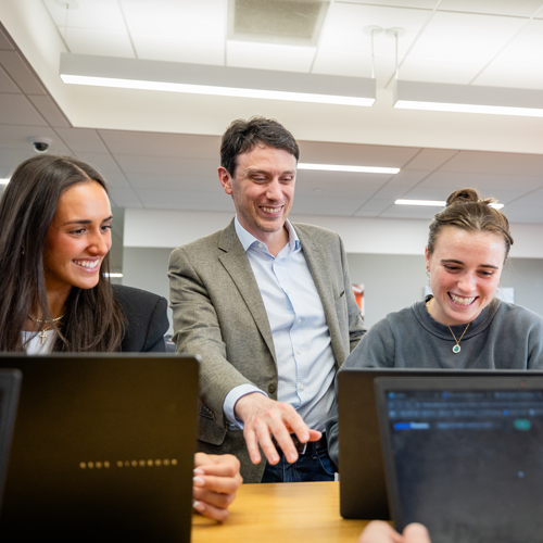 Professor helping students on computers