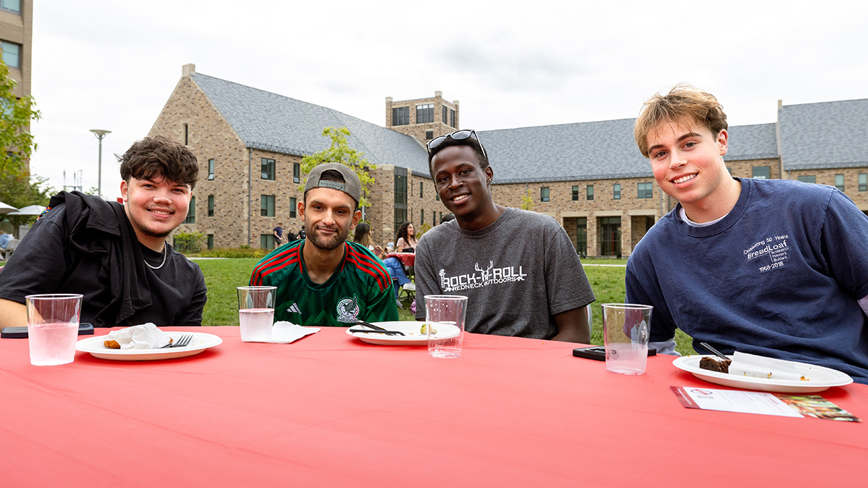 four people sitting at a table and smiling