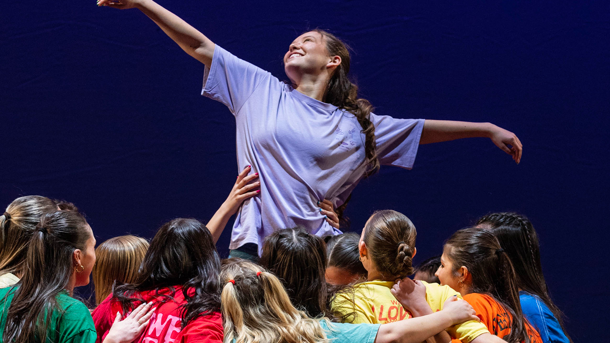 Dancers holding another dancer in the air