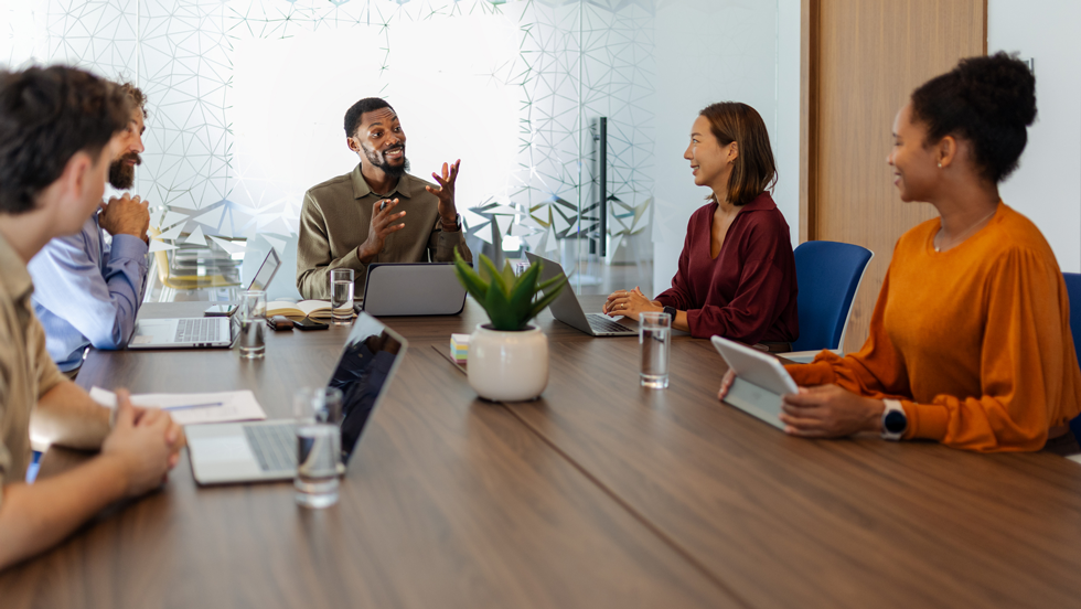 Professionals sitting around conference table talking