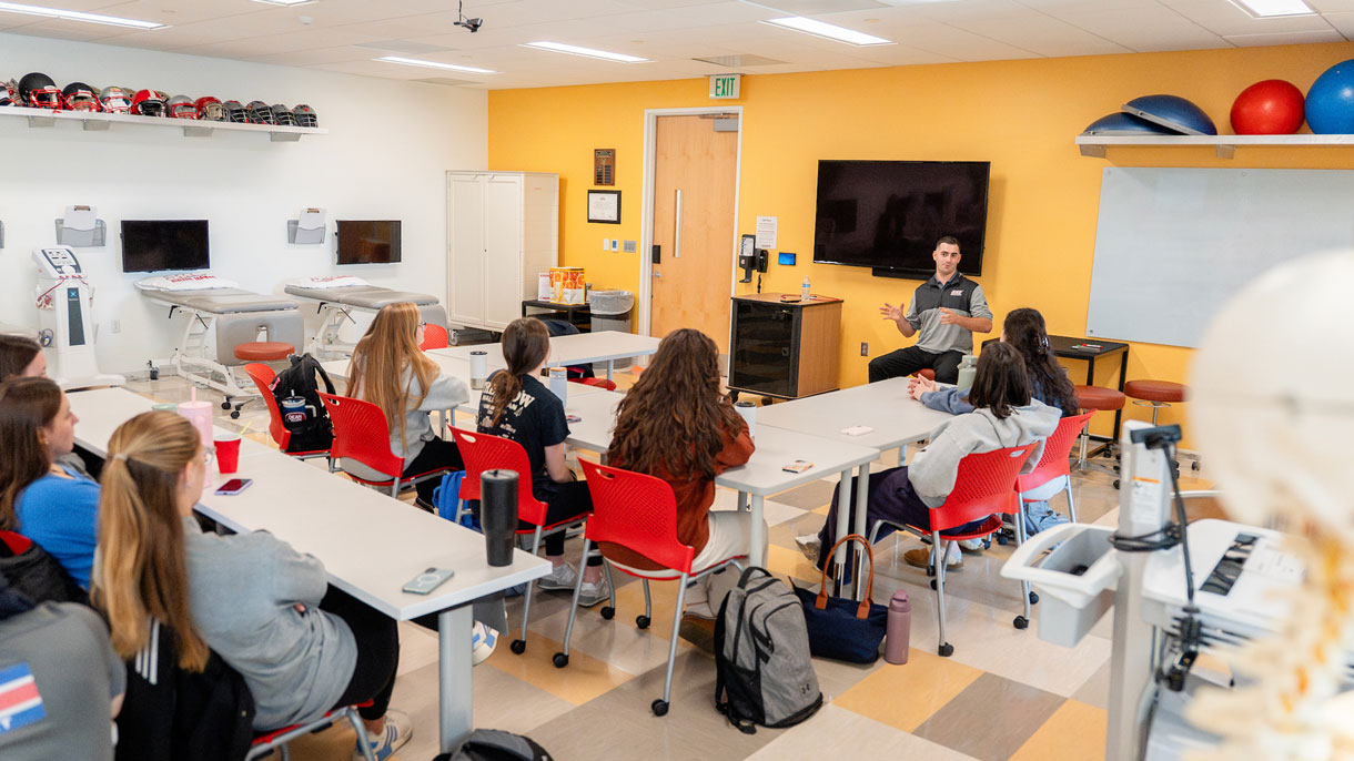 Students listening to professor in lab