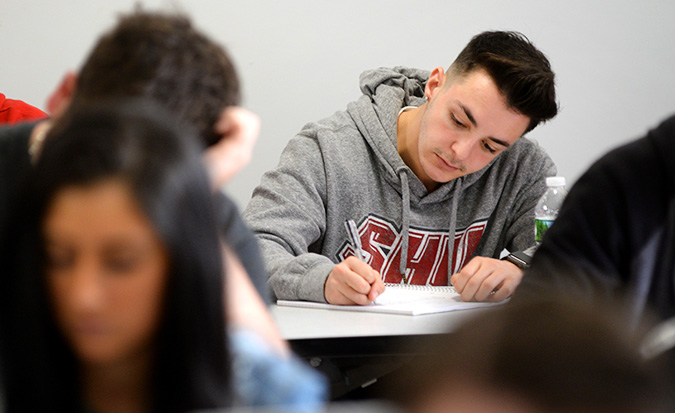 Student writing at his desk