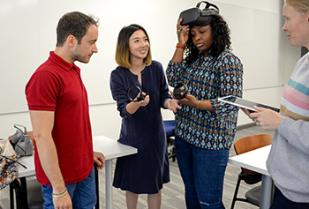 a professor shows students virtual reality equipment