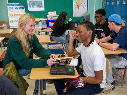college mentors helping middle school-aged mentees with school work