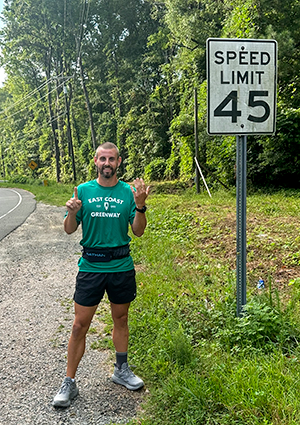 Ian Farley next to speed limit sign