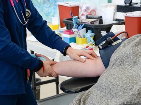 a nurse preps a blood donor