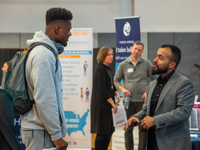 Student talking to professional at career fair