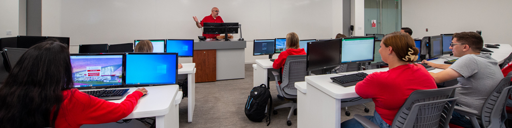 Students in computer lab listening to teacher
