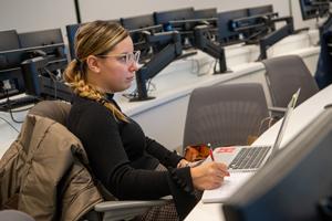Woman taking notes in classroom