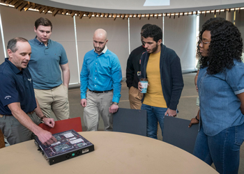 Man showing equipment to group of students
