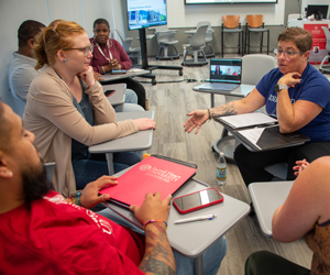 Students in classroom sitting in a circle talking