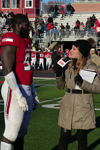 Interviewing football player on field