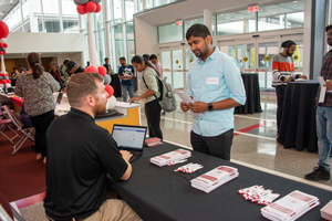 Student talking to man at table