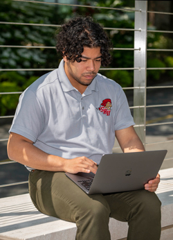 Man sitting outside using laptop