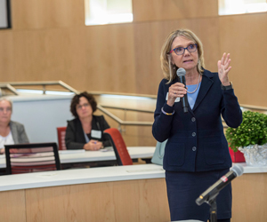 Woman Talking Into Microphone in front of audience