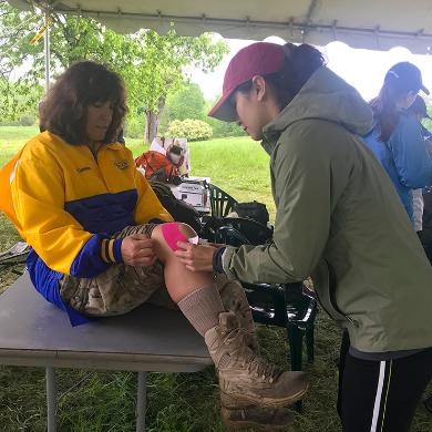 OT student taping a veteran's knee at an archeological dig