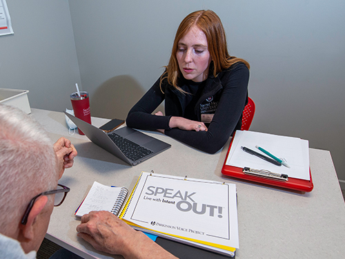 A college speech-language pathology student working with a client