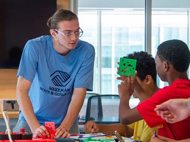 Joaquin Camaran works with Wakeman camp students in the IDEA Lab at Sacred Heart University
