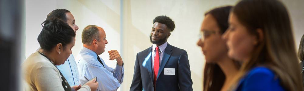 Professionally dressed student talking to employer at Career Fair