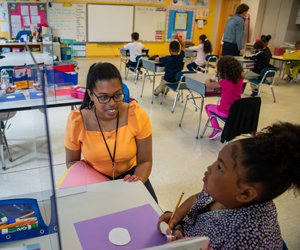Teacher helping student in classroom