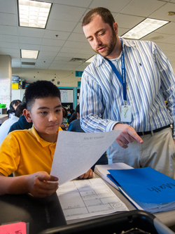 Teacher helping student in classroom