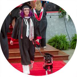 Layla the dog with her person at commencement