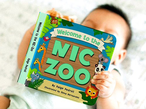 Baby holding NIC Zoo book